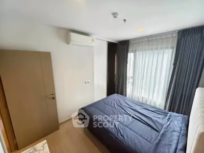 Cozy bedroom with modern furnishings and large window for natural light