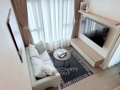 Modern living room with cozy sofa, stylish decor, and large TV, perfect for relaxation.