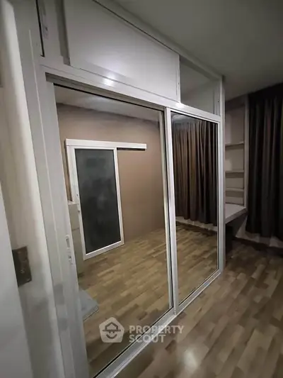 Modern bedroom with sliding glass doors and wooden flooring