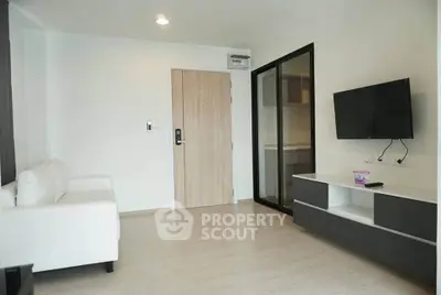 Modern living room with sleek furniture and wall-mounted TV in a stylish apartment.