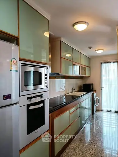 Modern kitchen with sleek appliances and ample storage in a stylish apartment.