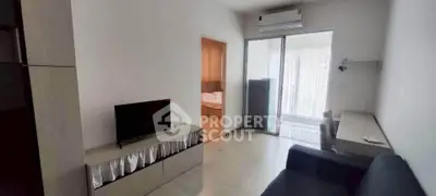 Modern living room with TV, sofa, and balcony access in a stylish apartment.
