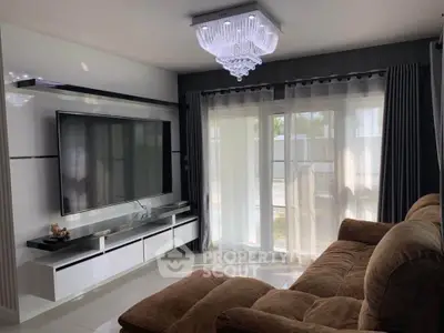 Luxurious living room with large TV and elegant chandelier