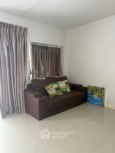 Cozy living room with brown sofa and elegant curtains, perfect for relaxation.
