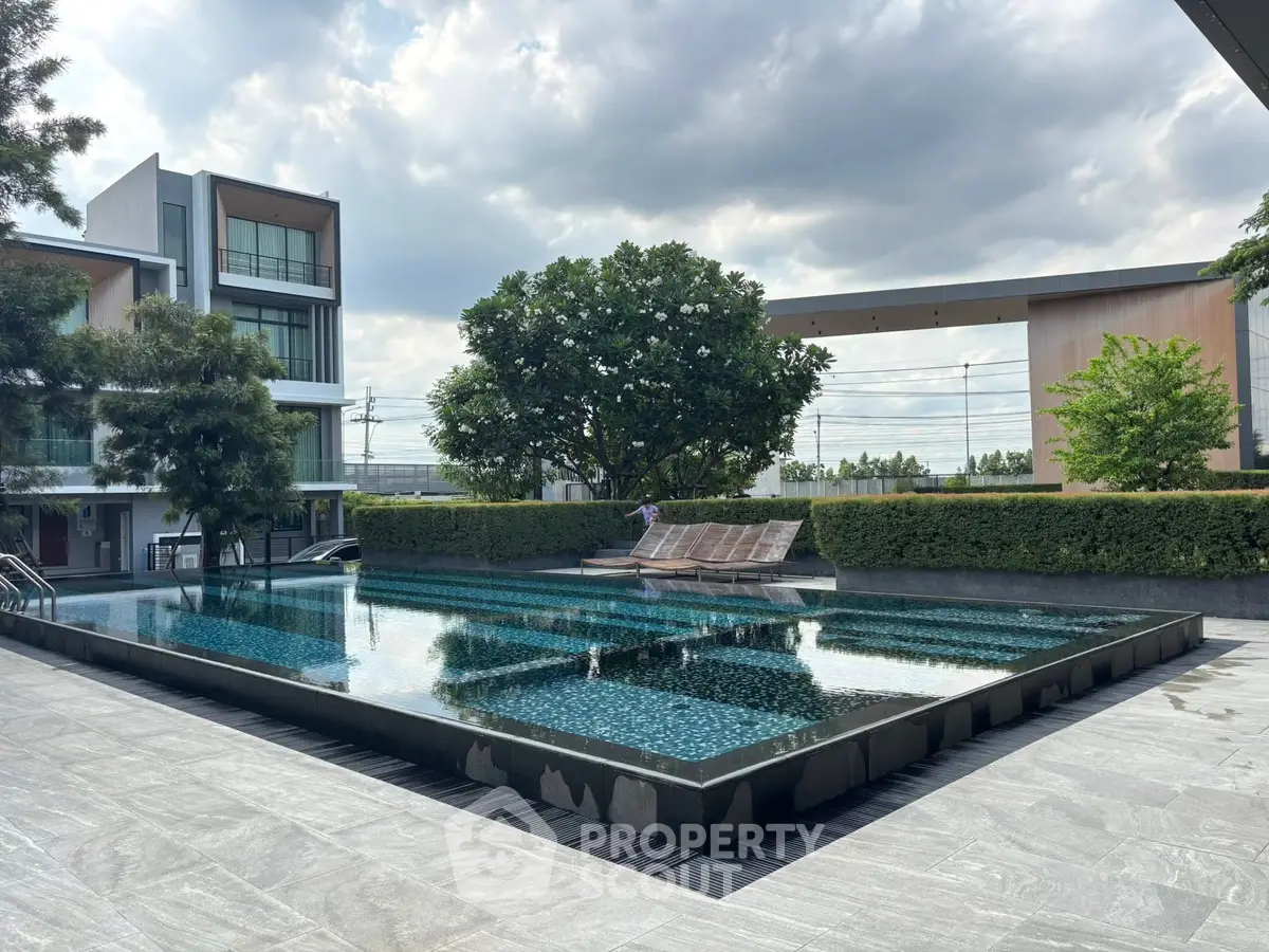 Luxurious outdoor pool area with modern architecture and lush greenery, perfect for relaxation and leisure.