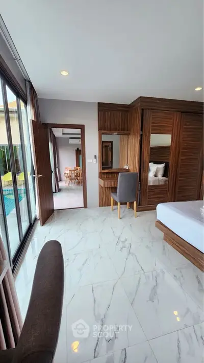 Luxurious bedroom with pool view and elegant wooden furnishings