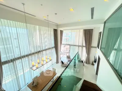 Luxurious modern living room with high ceilings and large windows offering stunning views.