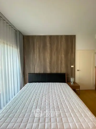 Modern bedroom with stylish wood panel wall and large window