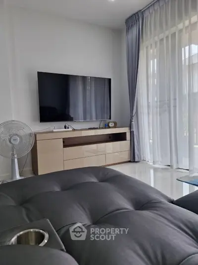 Modern living room with sleek TV setup and elegant curtains