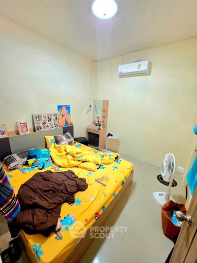 Cozy bedroom with vibrant bedding and air conditioning, perfect for restful nights.