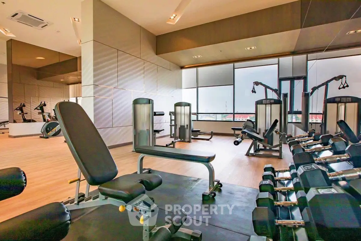 Modern gym with state-of-the-art equipment and mirrored walls in a luxury building.