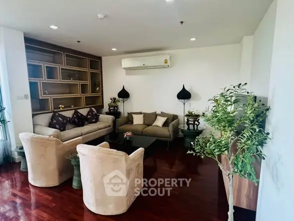 Elegant living room with plush seating and modern decor, featuring hardwood floors and built-in shelving.