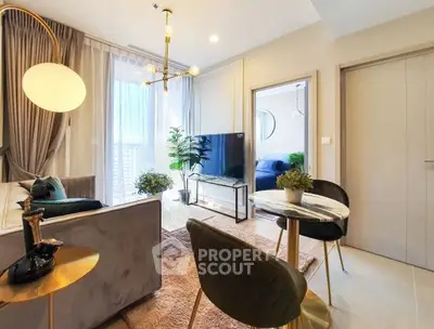 Modern living room with elegant decor and natural light, featuring a cozy seating area and stylish lighting.