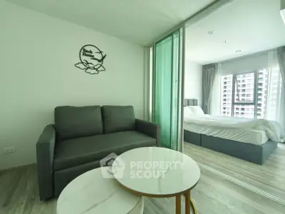 Modern apartment with cozy living room and stylish bedroom, featuring sleek furniture and large windows.