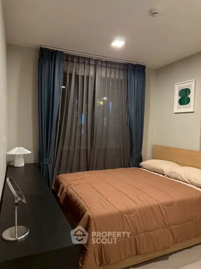 Cozy bedroom with modern decor and large window with curtains.