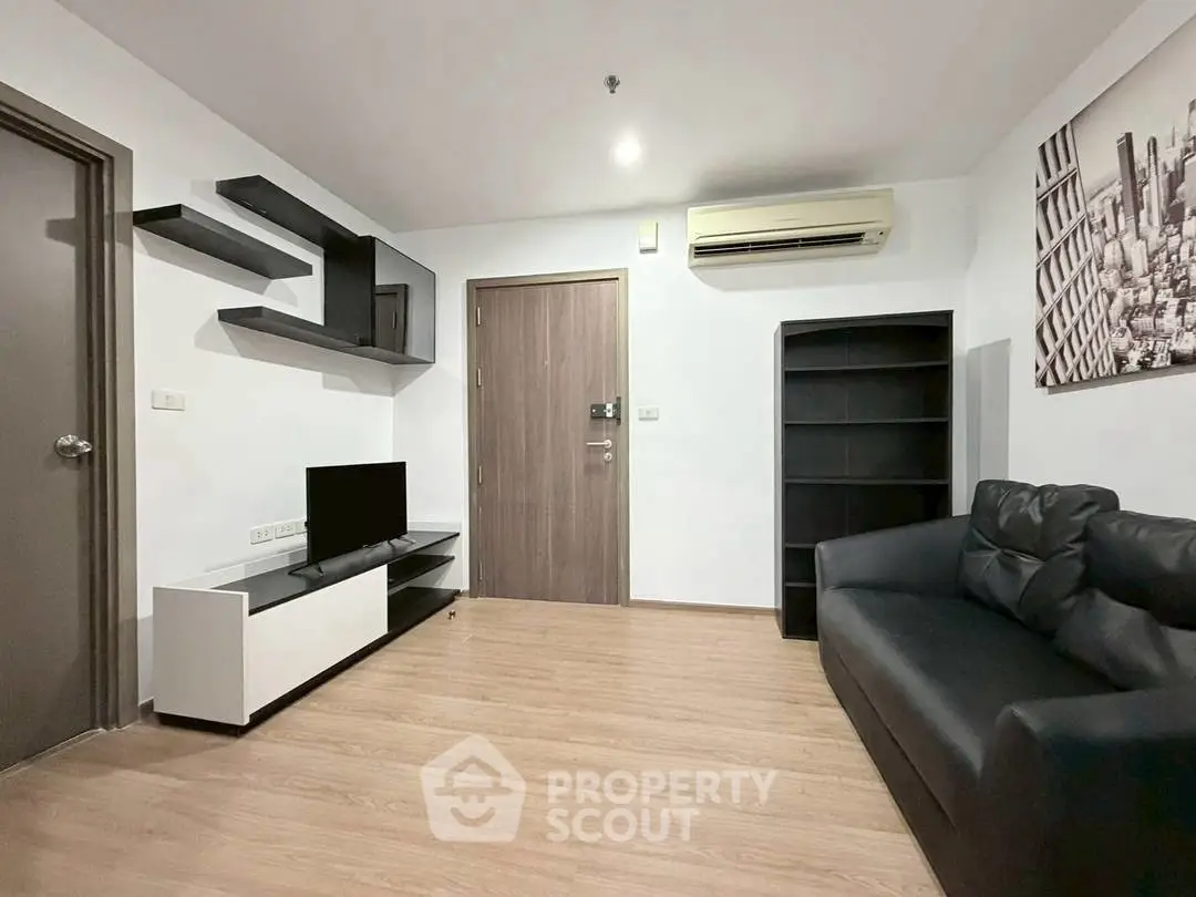 Modern living room with sleek black furniture and wall-mounted shelves, featuring a minimalist design.