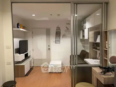 Modern living room with stylish decor and glass partition, featuring a cozy workspace and entertainment area.