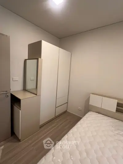 Modern bedroom with sleek wardrobe and cozy bed in minimalist design.