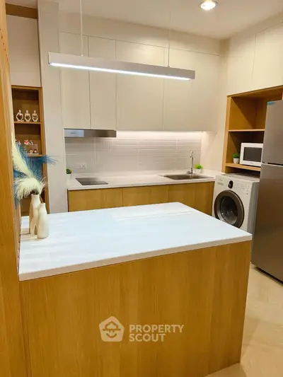 Modern kitchen with sleek cabinetry, integrated appliances, and stylish lighting in a contemporary apartment.
