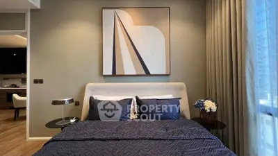 Elegant bedroom with modern decor and stylish artwork, featuring a cozy bed and soft lighting.
