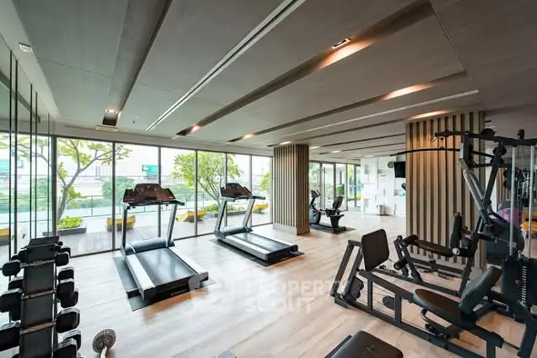 Modern gym with state-of-the-art equipment and large windows offering a scenic view.