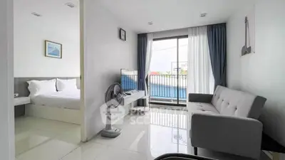 Modern apartment with bright living room and bedroom, featuring sleek furniture and large windows.