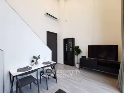 Modern living room with high ceiling, sleek furniture, and minimalist decor