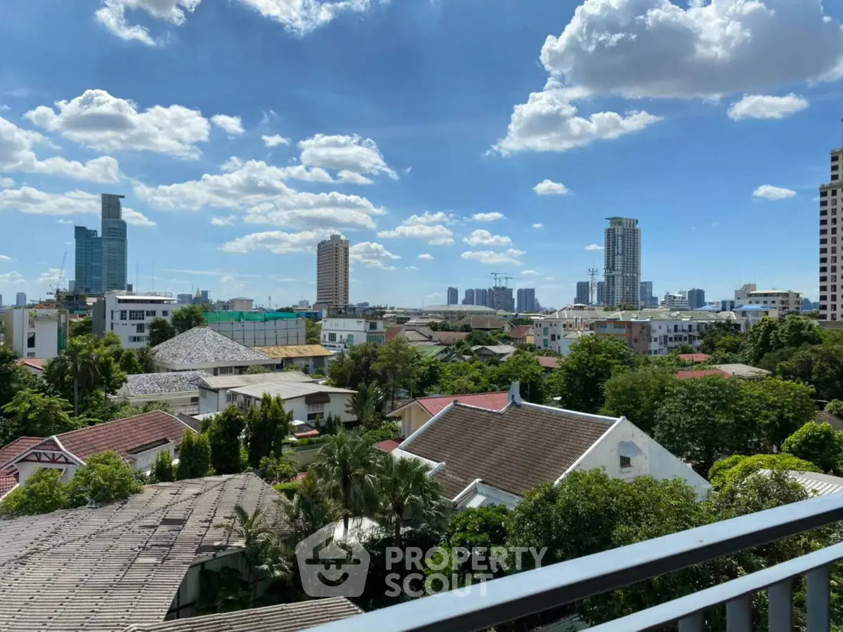 Stunning cityscape view from a balcony overlooking lush greenery and modern skyline.