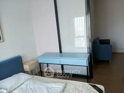 Modern bedroom with stylish blue furniture and wooden flooring, featuring a cozy bed and sleek design.