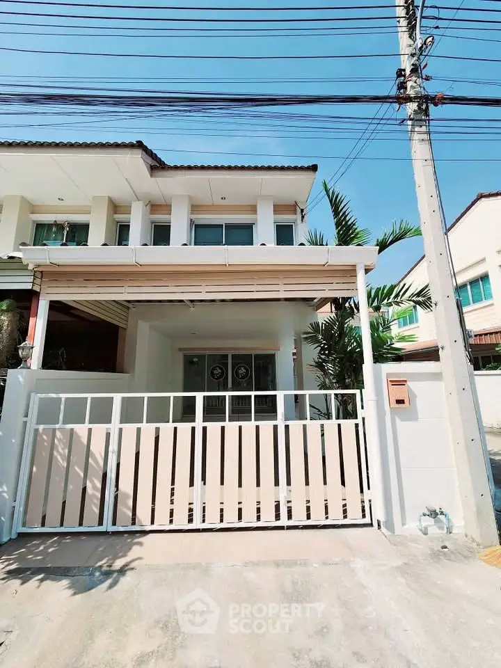 Charming two-story house with gated entrance and modern facade in a serene neighborhood.