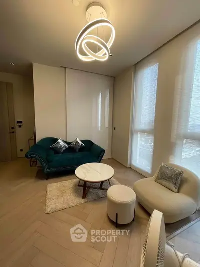 Modern living room with stylish furniture and elegant lighting, featuring a cozy sofa and chic armchair.