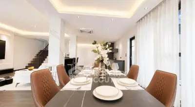 Luxurious dining area with elegant table setting and modern lighting in a spacious open-plan living space.