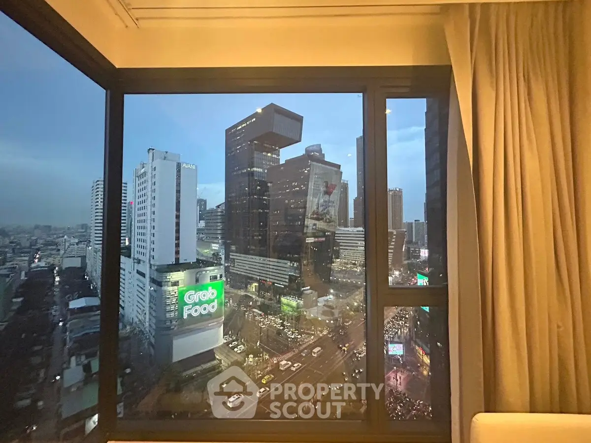 Stunning cityscape view from a high-rise apartment window at dusk, showcasing urban living.