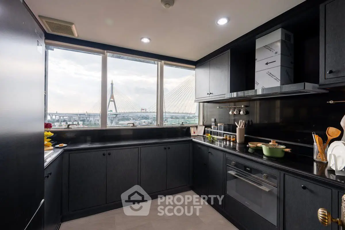 Modern kitchen with sleek black cabinets and stunning bridge view