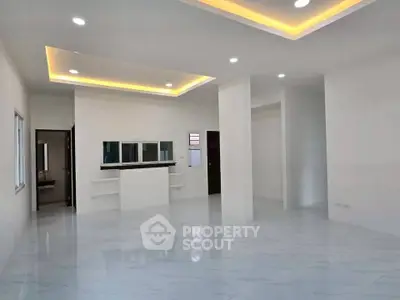 Spacious modern living room with recessed lighting and sleek marble flooring.