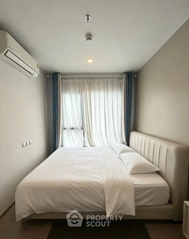 Cozy bedroom with modern decor and natural light, featuring a comfortable bed and elegant curtains.