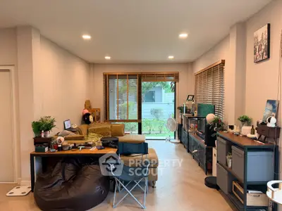 Spacious living room with modern decor and large windows overlooking garden