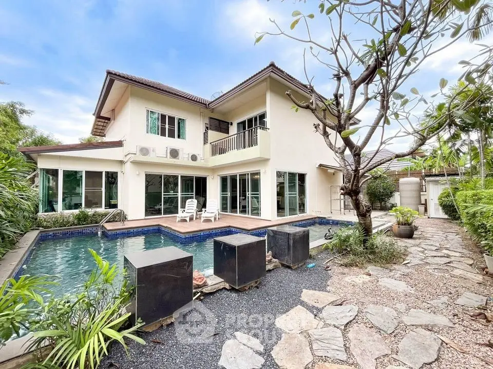 Stunning two-story home with private pool and lush garden in serene setting.