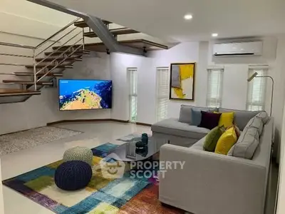 Modern living room with stylish staircase and colorful decor