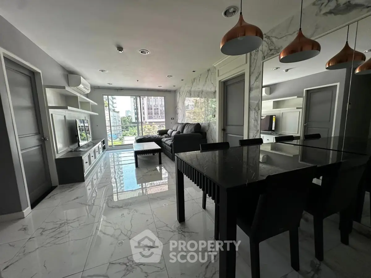 Modern living room with marble flooring and stylish decor in a high-rise apartment.