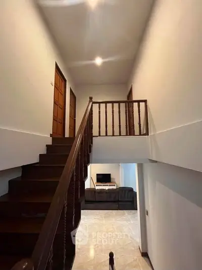 Spacious two-story home interior with wooden staircase and cozy living area.
