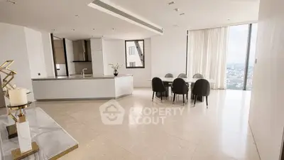 Luxurious open-plan living room with city view and modern kitchen.