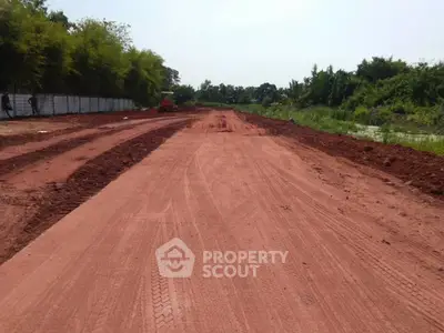 Expansive land plot with red soil, ideal for development opportunities.