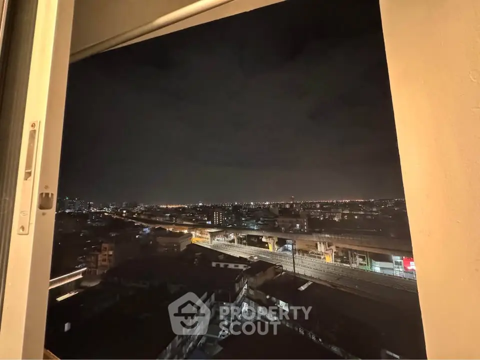 Stunning night cityscape view from high-rise window overlooking urban skyline.