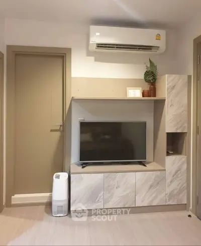 Modern living room with sleek TV unit and air conditioning, perfect for comfortable living.
