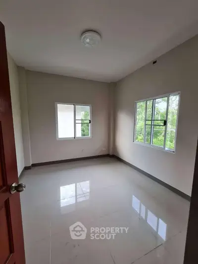 Bright empty room with large windows and glossy tiled floor, perfect for customization.