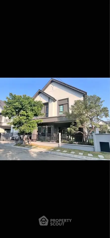 Charming modern house with lush greenery and spacious front yard in a serene neighborhood.