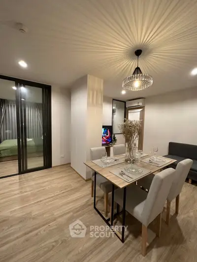 Modern dining area with elegant lighting and open view to bedroom