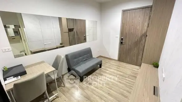 Modern compact living room with sleek wooden flooring and minimalist furniture.