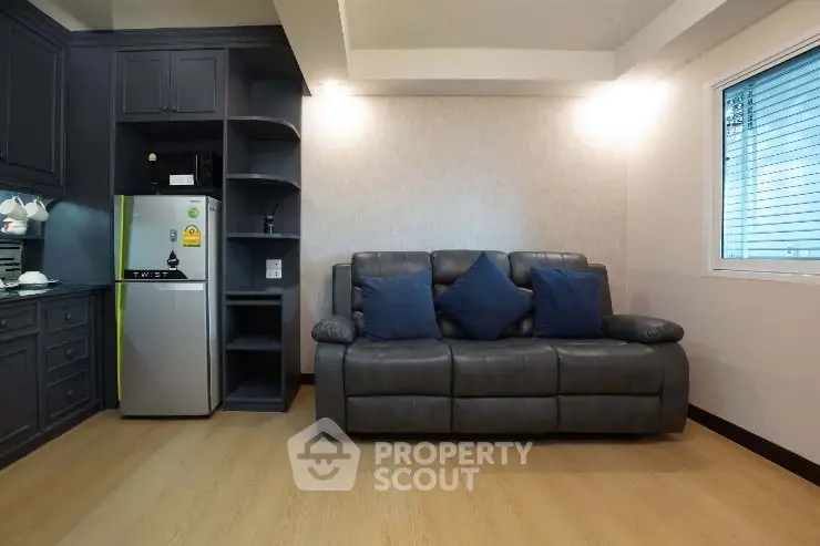 Modern living room with sleek gray sofa and compact kitchen area